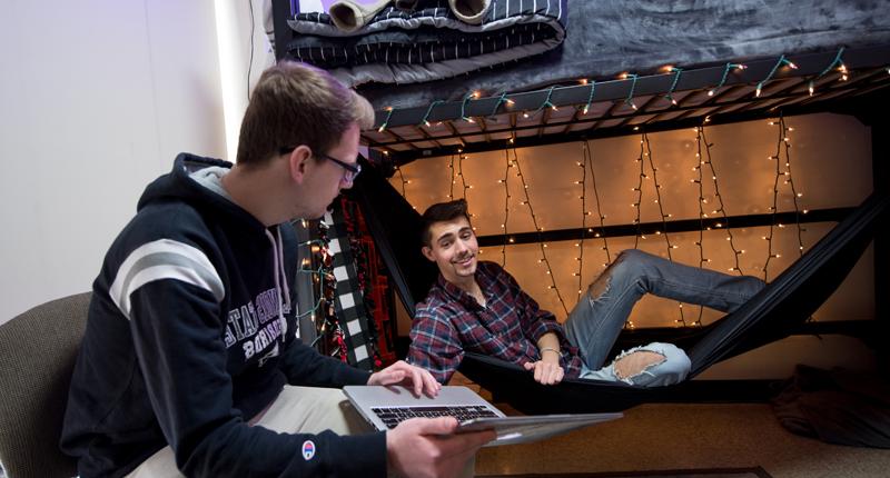 Two students hanging out in their dorm room.